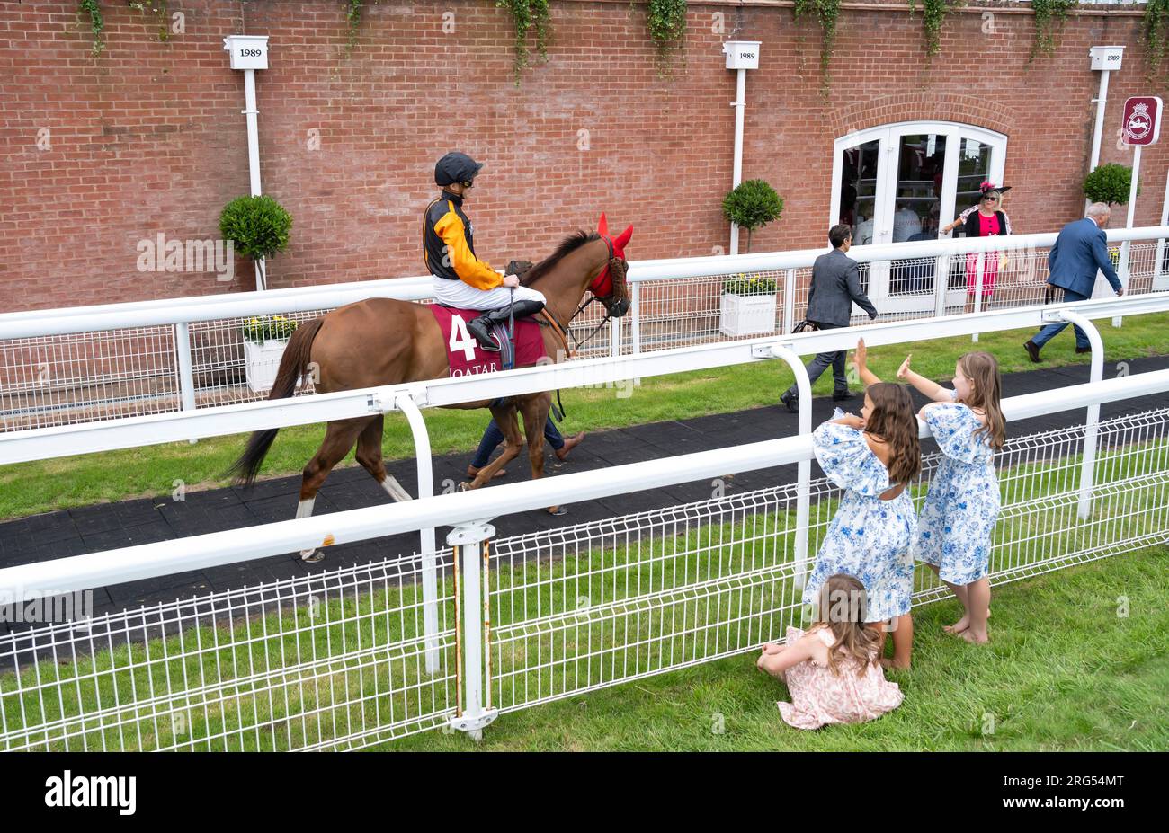 Kinder winken Jockey James Doyle zu, während er sich am 4. Tag des Qatar Goodwood Festival Meeting 2023 auf der Rennbahn Goodwood in Chichester auf Raasel aufmacht Stockfoto