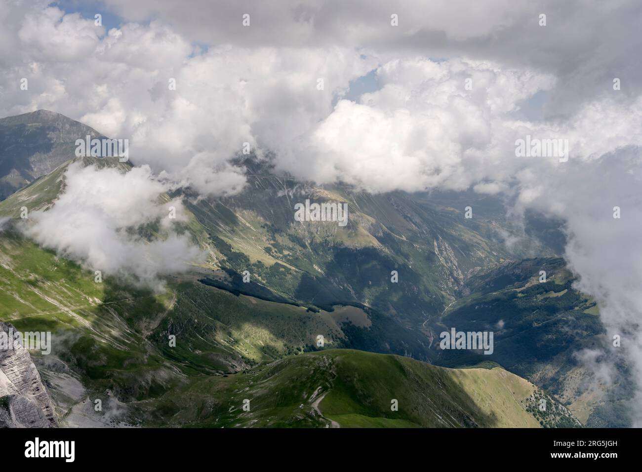 Luftlandschaft, aus einem Segelflugzeug, mit kargen östlichen Hängen der Vettore Range und Meeresbrise Wolken, die von Norden in hellem Sommerlicht aufgenommen werden Stockfoto
