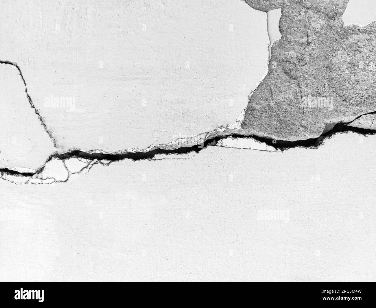 Großer, langer, gewundener Riss an der Wand. Bauarbeiten an der Wand eines alten Gebäudes. Speicherplatz kopieren. Schwarzweißfoto. Selektiver Fokus. Stockfoto Großer, langer, gewundener Riss an der Wand. Bauarbeiten an der Wand eines alten Gebäudes. Speicherplatz kopieren. Schwarzweißfoto. Selektiver Fokus. Stockfoto