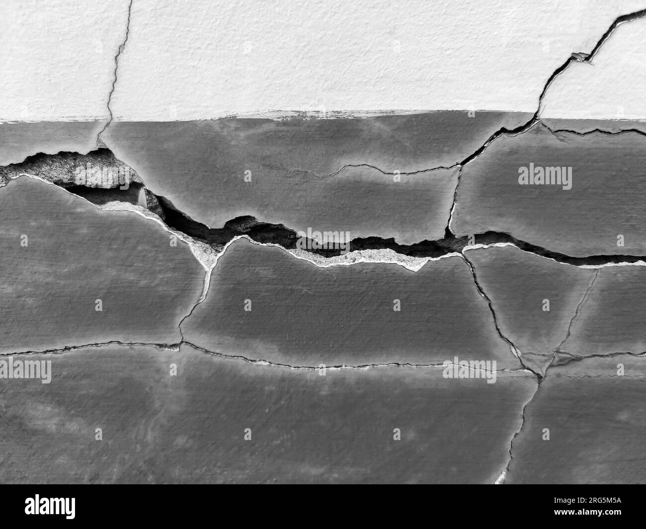 Großer, langer, gewundener Riss an der Wand. Bauarbeiten an der Wand eines alten Gebäudes. Speicherplatz kopieren. Schwarzweißfoto. Selektiver Fokus. Stockfoto Großer, langer, gewundener Riss an der Wand. Bauarbeiten an der Wand eines alten Gebäudes. Speicherplatz kopieren. Schwarzweißfoto. Selektiver Fokus. Stockfoto