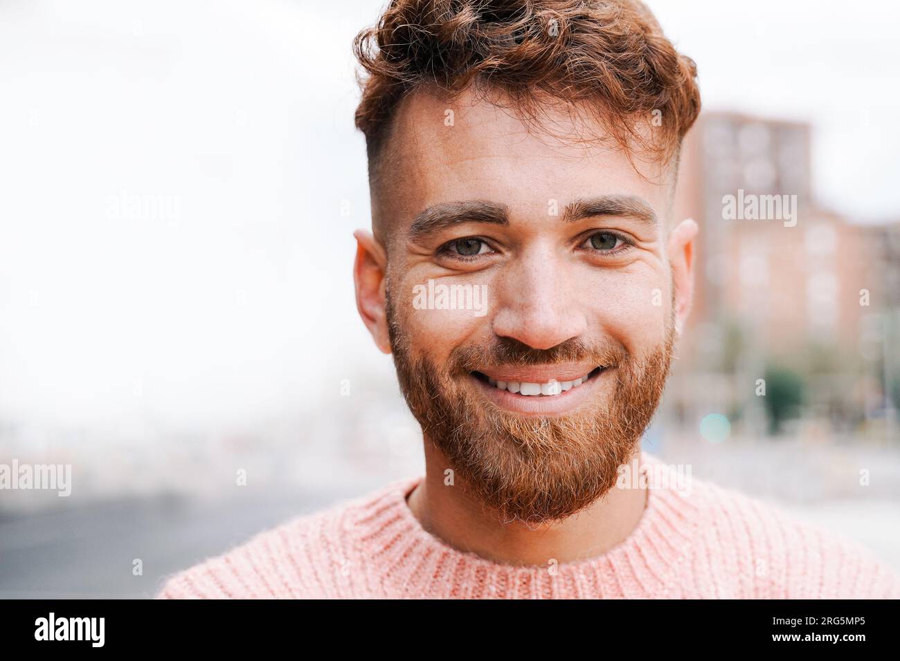 Fröhlicher Ingwerhaar-Mann, der draußen vor der Kamera lächelt - Diversity Community Concept Stockfoto