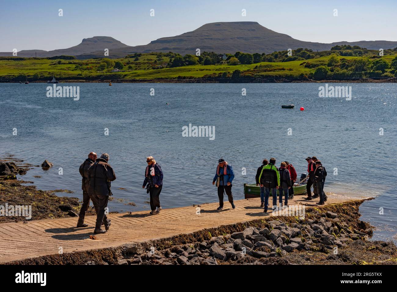 Dunvegan, Isle of Skye, Schottland, Vereinigtes Königreich. 5. Juni 2023 Kleine Bootsanlegestelle auf Loch Dunvegan, Isle of Skye, Großbritannien. Touristen warten auf eine Bootsfahrt. Stockfoto