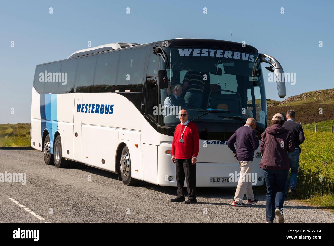 Isle of Skye, Schottland, Vereinigtes Königreich. 5. Juni 2023 Reiseleiter, der seine Passagiere nach einer Fotopause auf der Isle of Skye in Schottland wieder in den Tourbus eincheckt Stockfoto