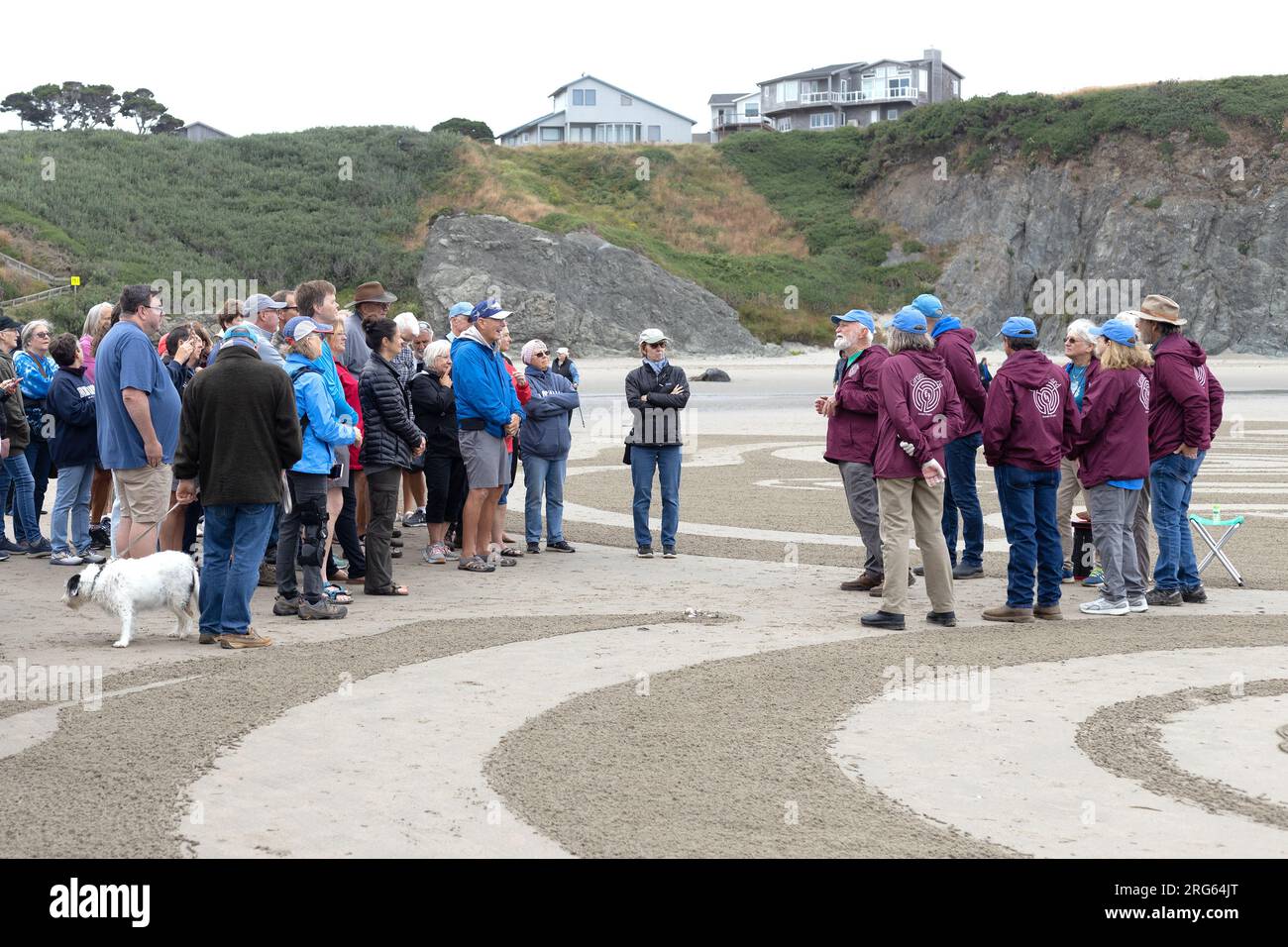 Der Sandlabyrinth-Künstler Denny Dyke und seine Crew sprechen vor dem Beginn eines Kreises auf dem Sand Labyrinth Walk in Bandon, Oregon. Stockfoto