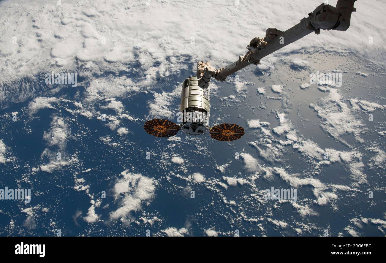 Der Canadarm2-Roboterarm greift aus, um das Cygnus-Frachtraum zu fangen, während es sich der ISS nähert. Stockfoto