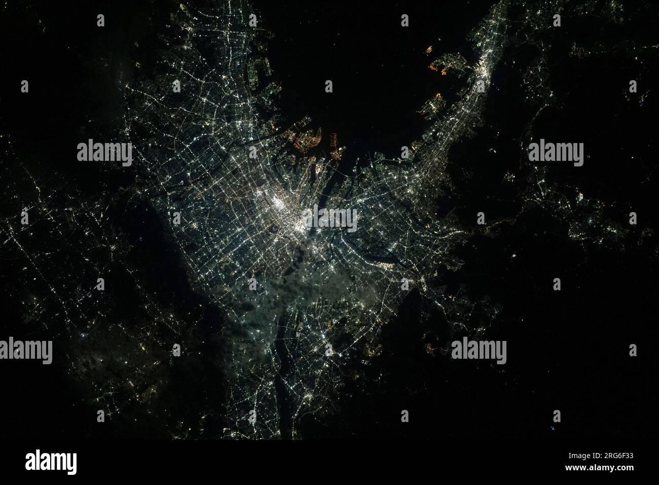 Blick aus dem All auf die hellen Lichter von Osaka, Japan, an der Bucht von Osaka Stockfoto