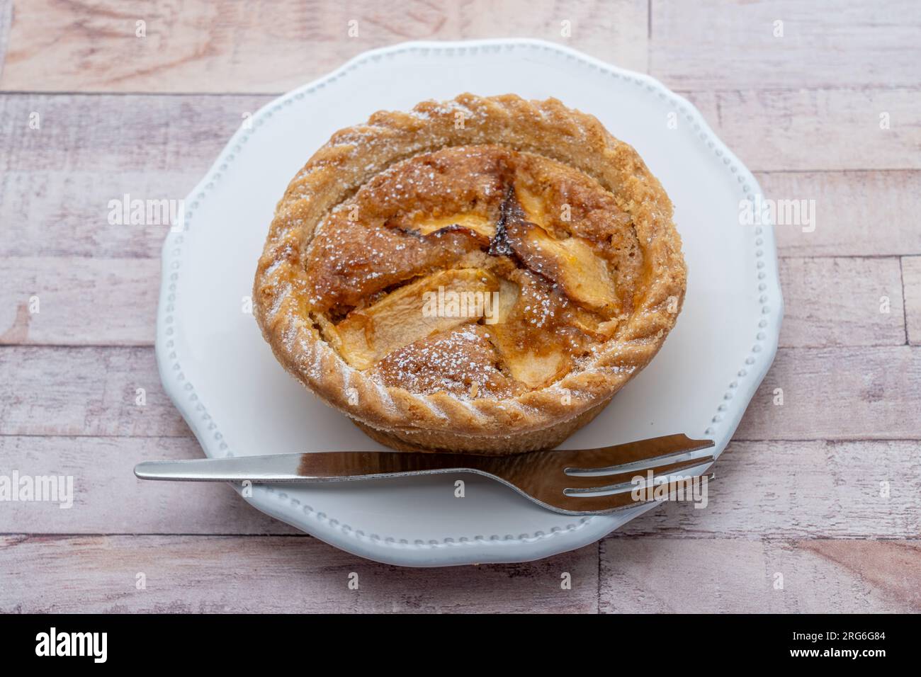 Ein Frangipankuchen auf einem kleinen Teller mit einer Gabel Stockfoto
