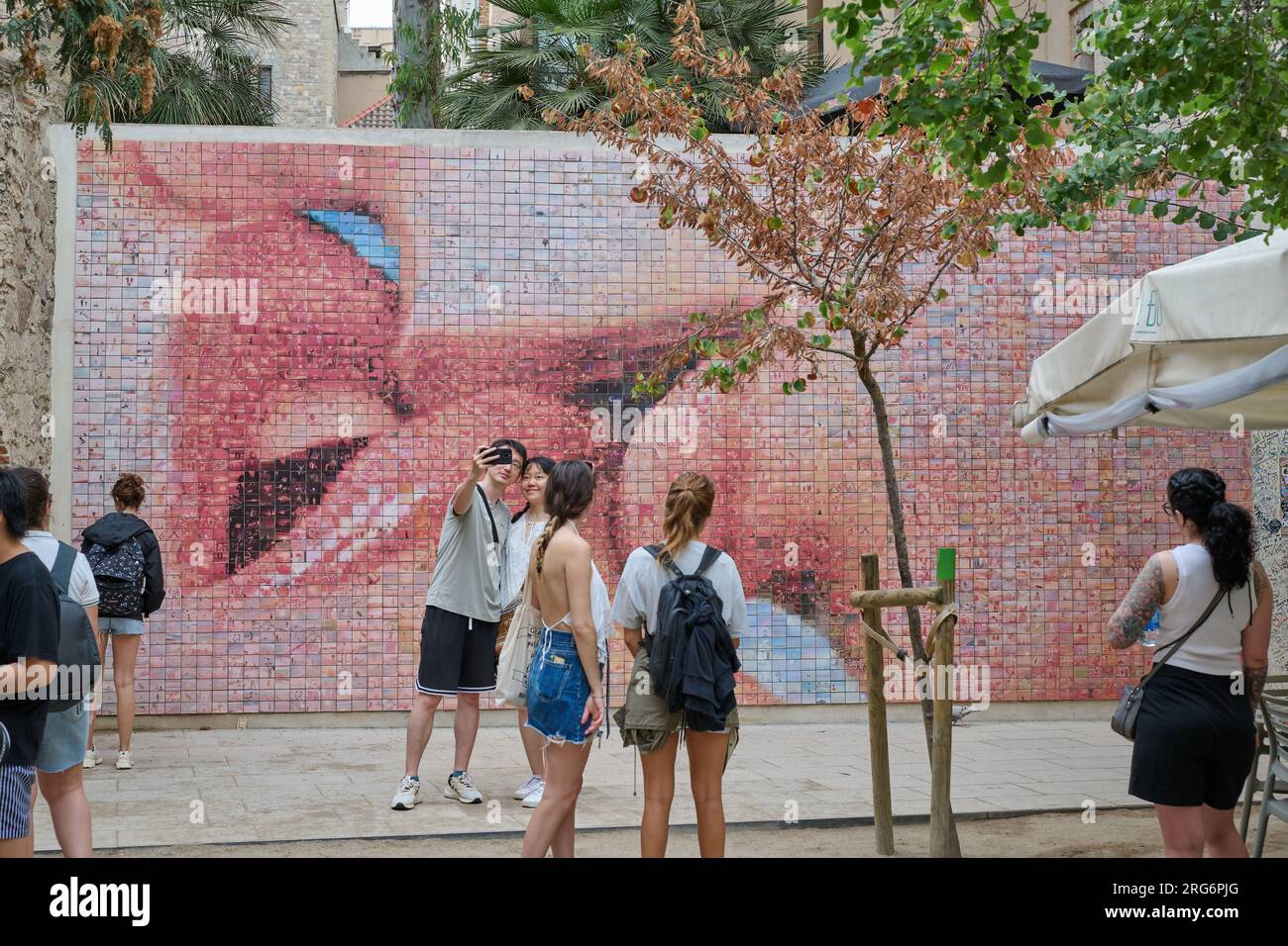 04.08.2023. Barcelona, ​​Spain, Wandbild des Kusses auf dem Platz Isidre Nonell mit einem Paar, das ein Selfie macht Stockfoto