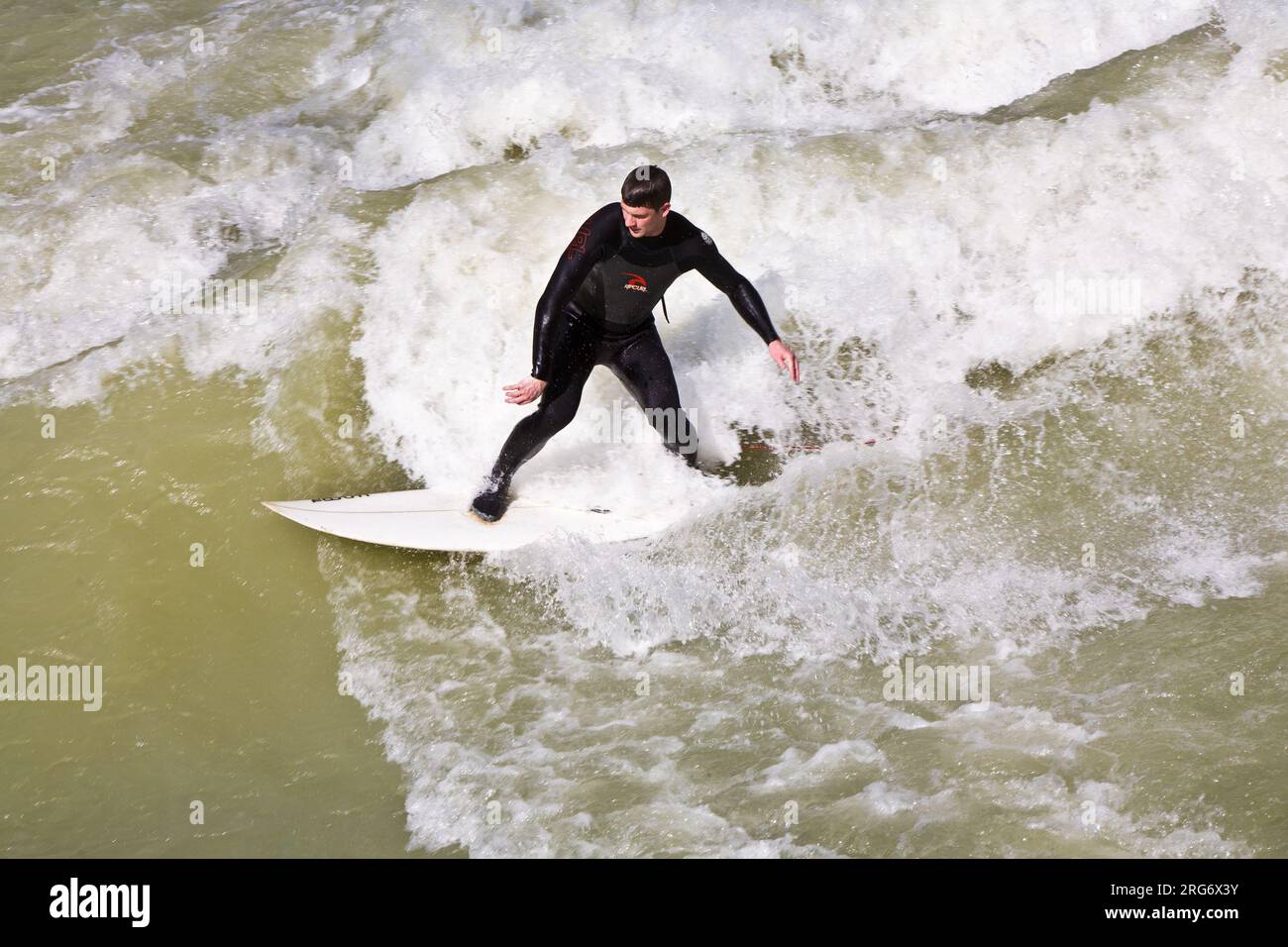 MÜNCHEN, DEUTSCHLAND - 07. APRIL: Surfer surft am Isar in riesigen Wellen zur Saisoneröffnung an der Wittelsbacher Brücke im Herzen Münchens am April Stockfoto