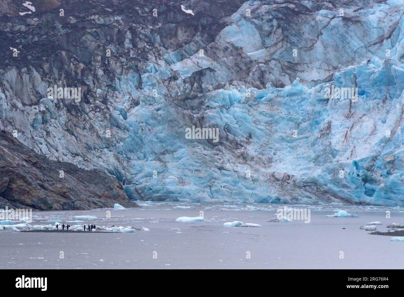 Besucher, die zwischen Eisbergen am Fuße des Lamplugh-Gletschers wandern Stockfoto