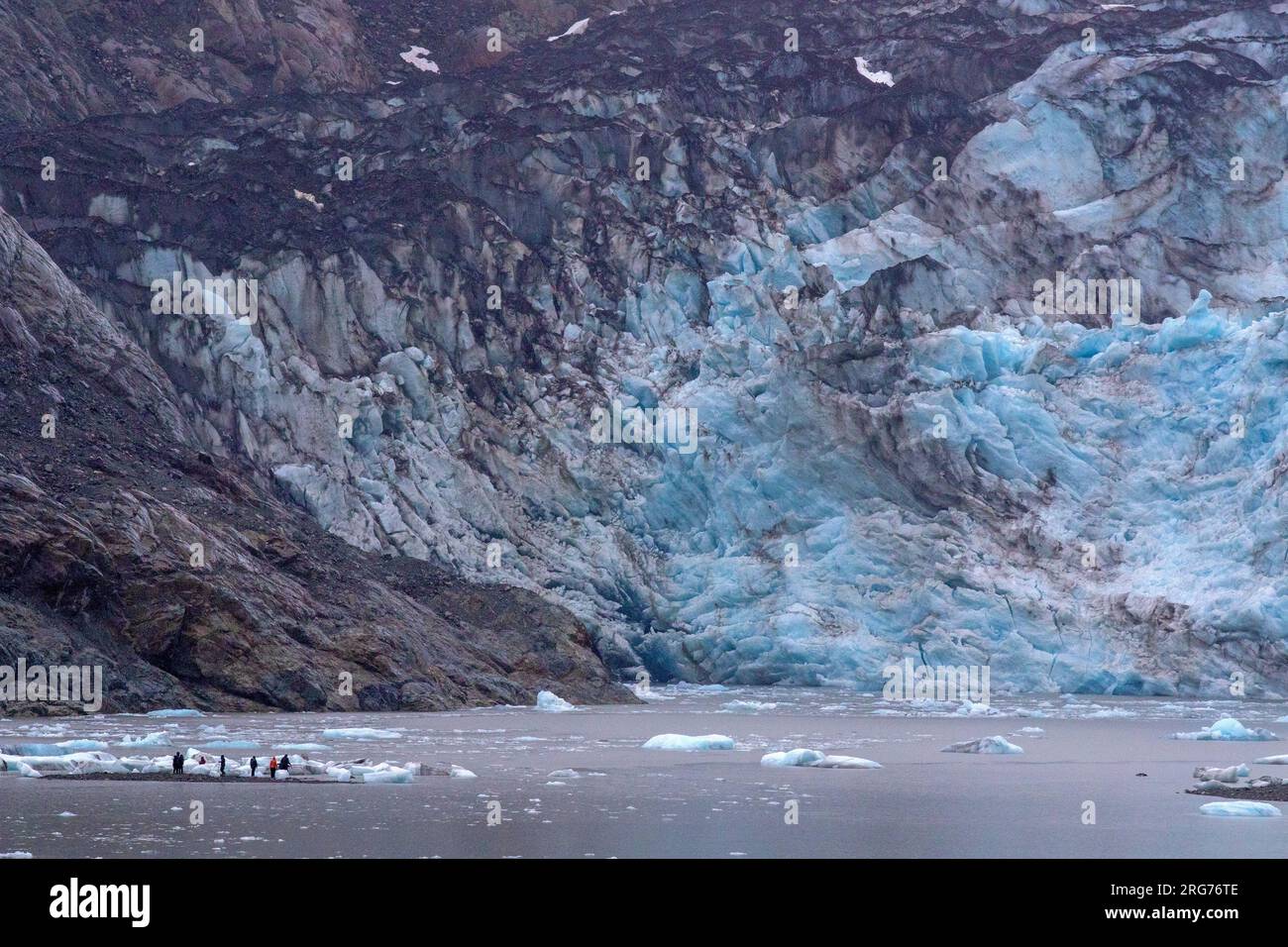 Besucher, die zwischen Eisbergen am Fuße des Lamplugh-Gletschers wandern Stockfoto