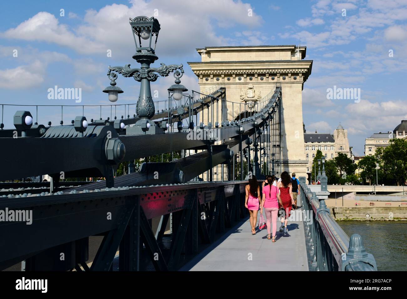 Ausblick auf die renovierte Kettenbrücke. Tourboot auf der Donau. Die Pest-Seite im Hintergrund. Sie wieder für die Öffentlichkeit zugänglich machen, Leute laufen. Stockfoto