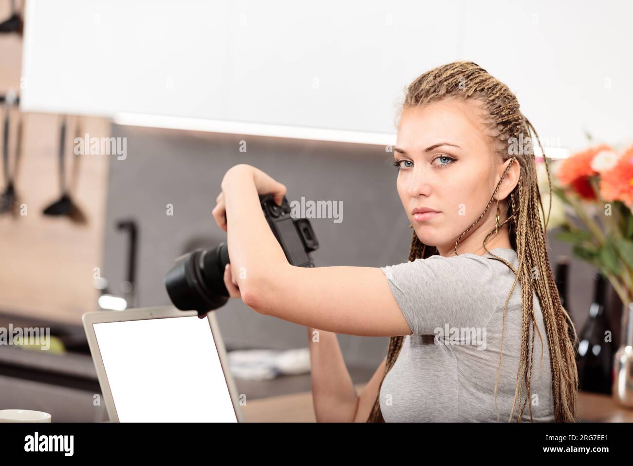 Mithilfe einer DSLR und eines Laptops, eines Amateurfotografen oder professionellen Fotografen mit Boxgeflecht-Haarexperimenten in der Küche, um kreativ zu wachsen Stockfoto
