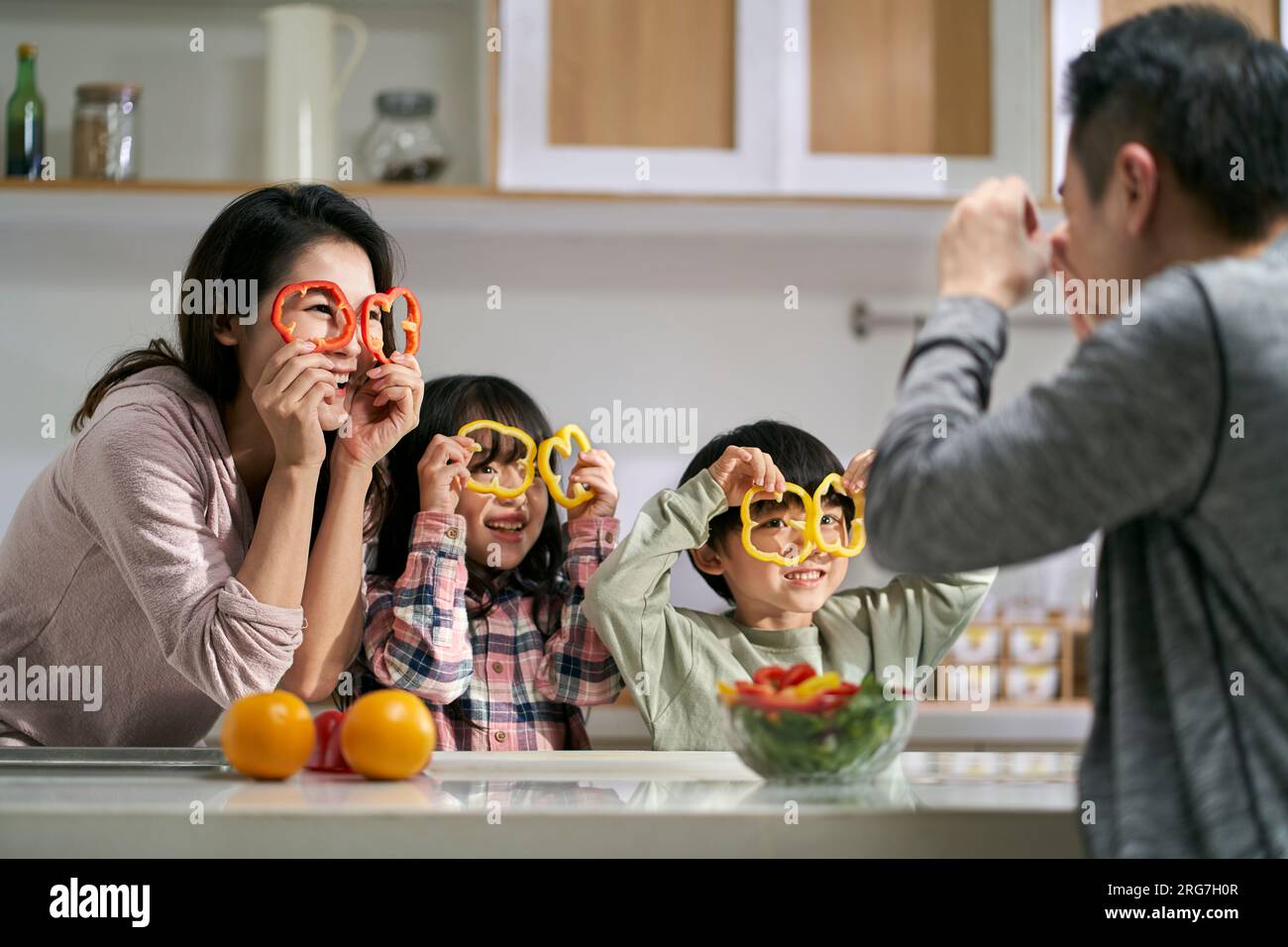 Glückliche asiatische Familie mit zwei Kindern, die Spaß zusammen in der Küche zu Hause haben Stockfoto