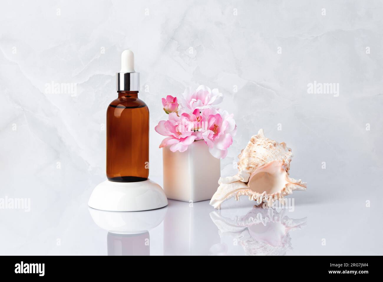 Gesichtsserum, Sea ​​shell. Braune Glasflasche, Fläschchen, Strauß rosa Frühlingsblumen. Aromatisches Massageöl und Kirschblüte. Natürlicher organischer Spa-Kosmos Stockfoto