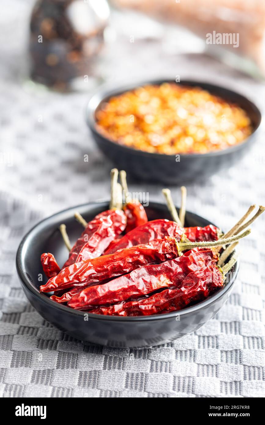Rote Chili-Paprika in der Schüssel auf der karierten Tischdecke. Stockfoto