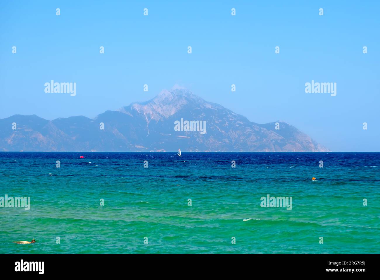 Panoramablick auf den türkisfarbenen Strand von Sarti Chalkidiki Griechenland und den Berg Athos im Hintergrund Stockfoto