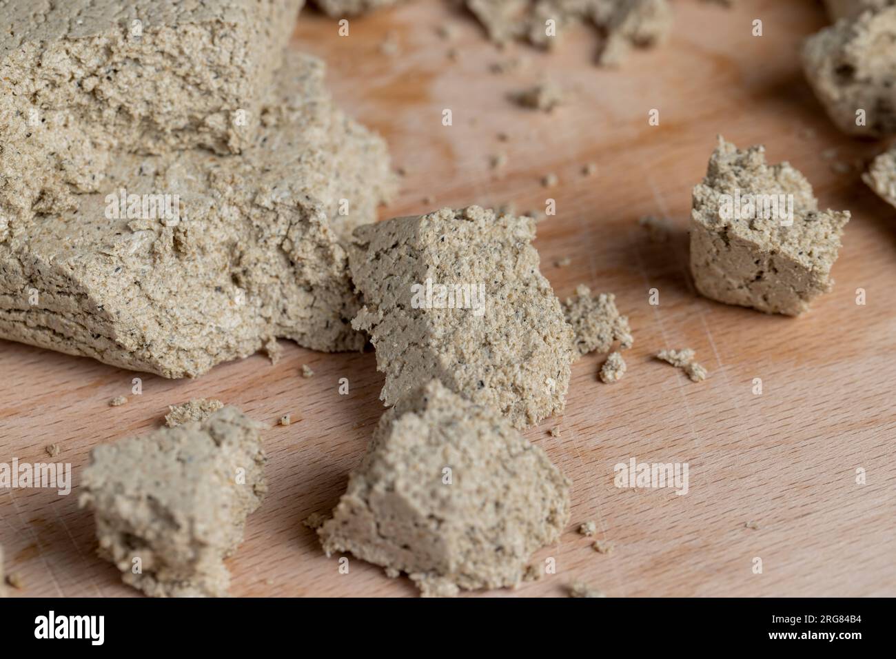 Sonnenblumenhalva zerbrochen in Stücke, Stücke von Halva Süßigkeiten auf einem Holzbrett Stockfoto