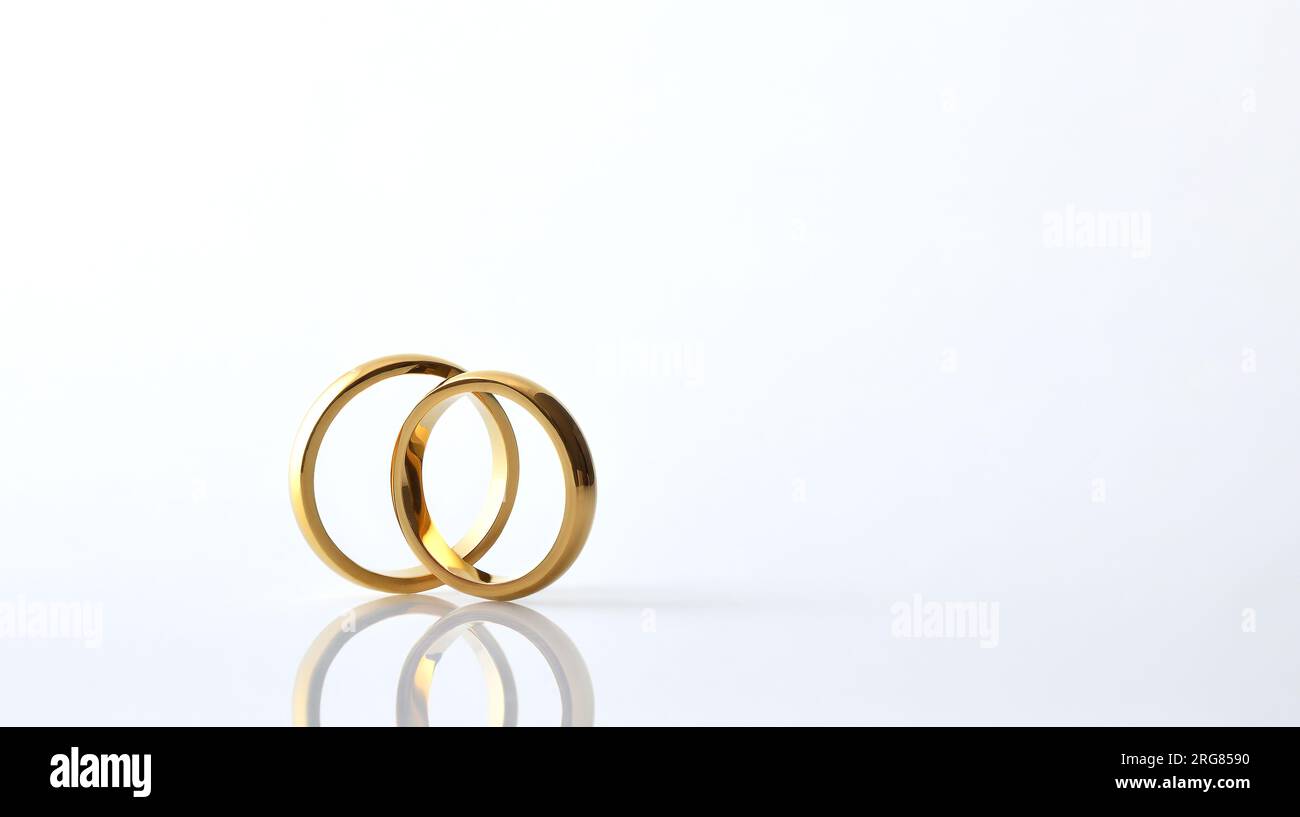 Detail mit zwei goldenen Eheringen auf Glasbasis und isoliertem weißem Hintergrund. Vorderansicht. Stockfoto