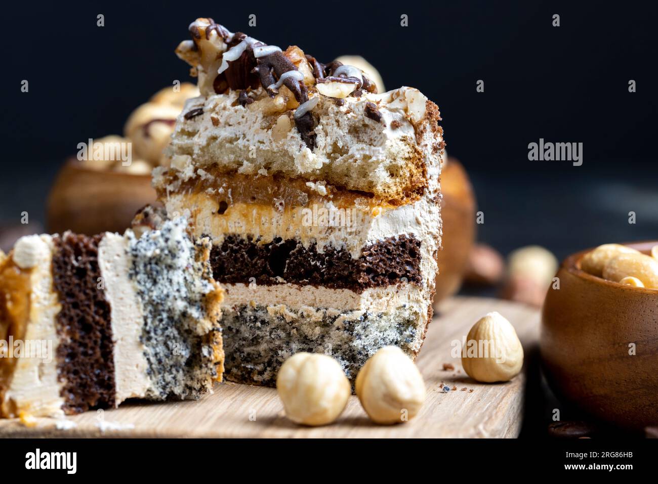 Mehrschichtiger Kuchen mit verschiedenen Schichten, Karamell, Mohn und Cremeschichten Kuchen zum Dessert mit Nüssen Stockfoto