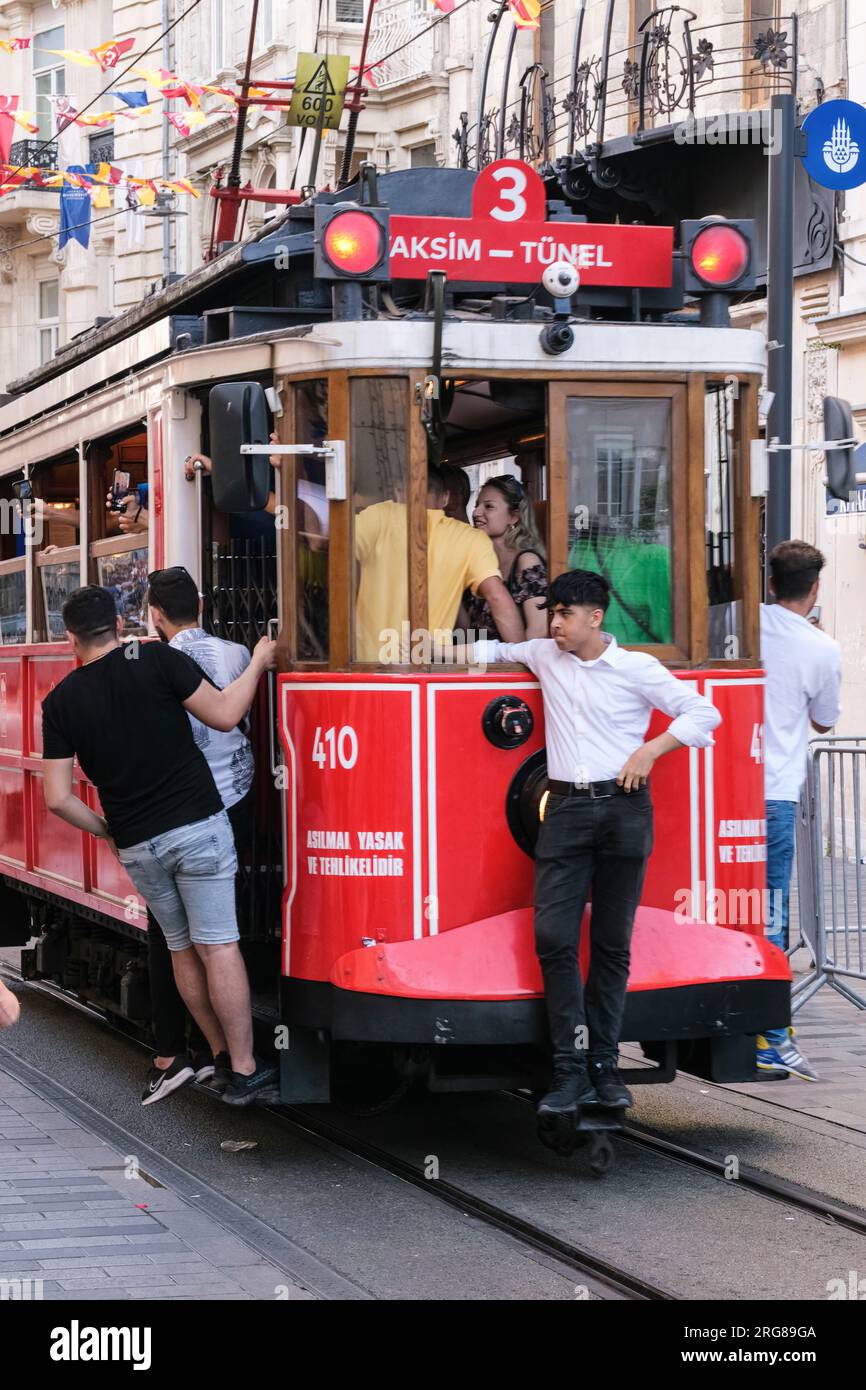 Istanbul, Türkei, Türkiye. Istiklal Street, junge Männer, die eine Fahrt mit dem Trolley machen. Stockfoto