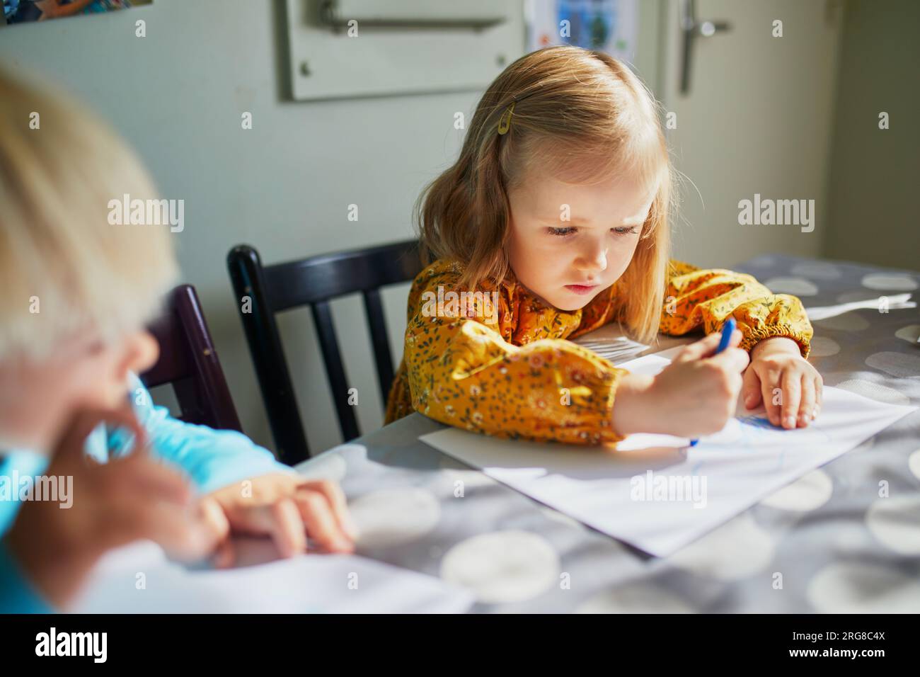Ein bezauberndes kleines Mädchen, das zu Hause, im Kindergarten oder im Vorschulalter mit Filzstift malt Stockfoto