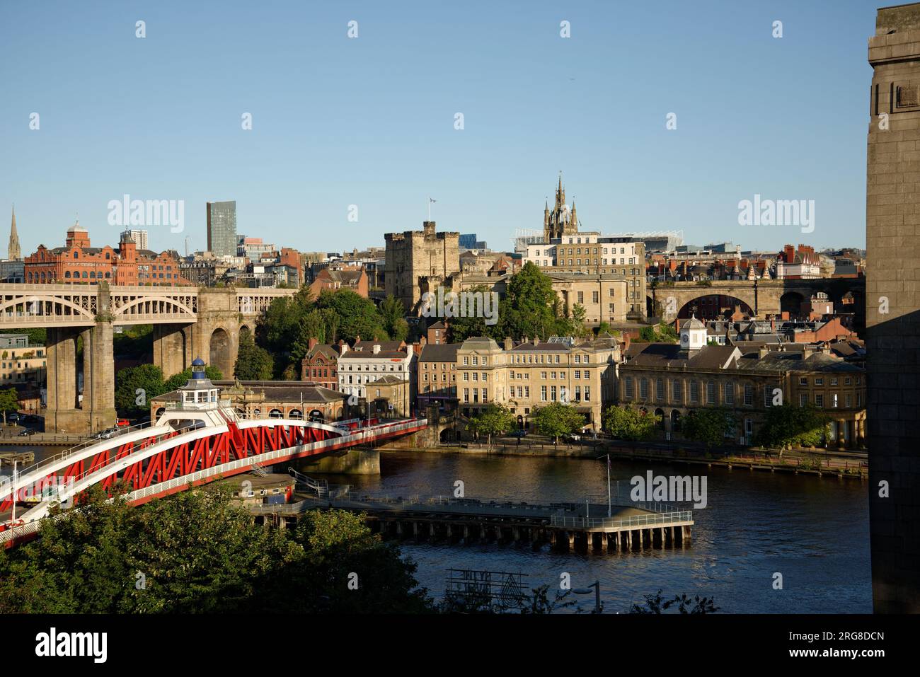 Die Swing Bridge in Newcastle. Rot-weiß bemalte Metallbrücke über den Fluss Tyne. Newcastle City im Hintergrund mit dem Fußballstadion. Stockfoto