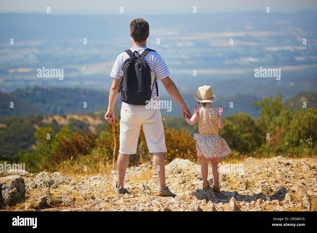 Vater und Tochter genießen einen wunderschönen Blick von der Spitze des Hügels in der Provence, Südfrankreich. Glückliche Familie mit zwei Personen, die zusammen reisen Stockfoto