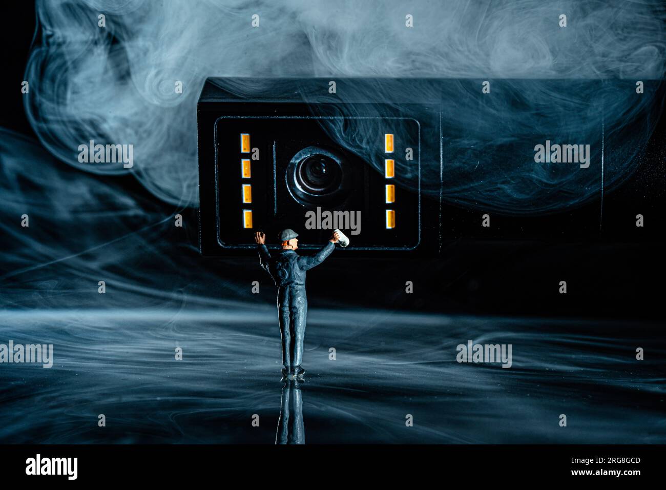 Objektivreiniger Miniatur Arbeiter in Uniform, reinigt Kameraobjektiv mit einem weichen fusselfreien Tuch Stockfoto