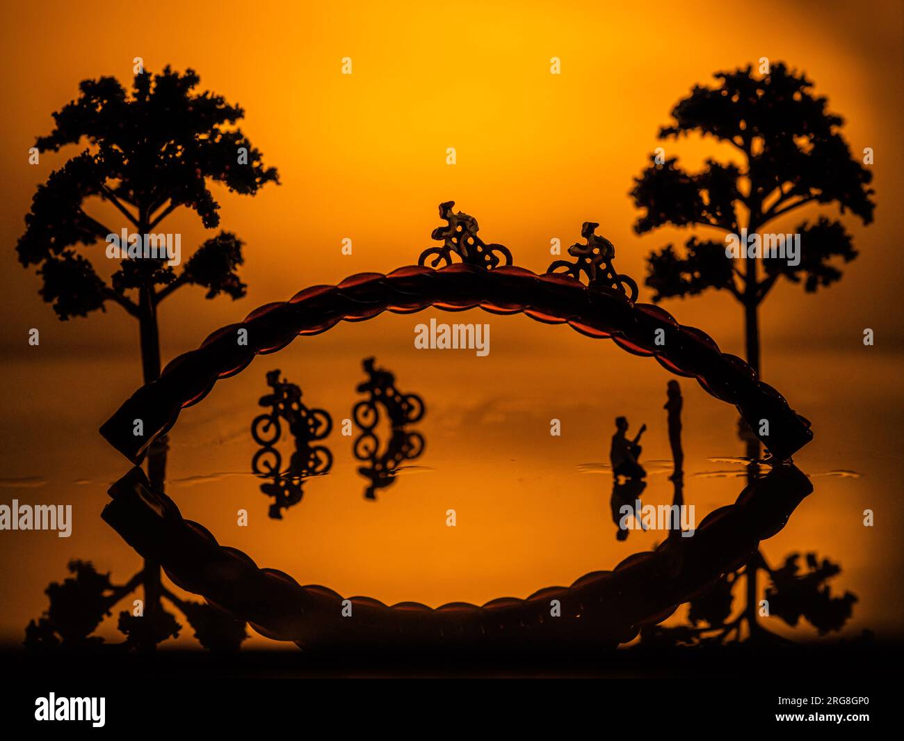Imaginary Park bei Sonnenuntergang Miniaturradfahrer und ein romantisches Paar Stockfoto