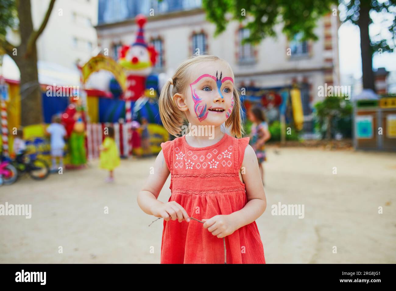 Kleines Vorschulmädchen mit Schmetterlingsgesichtsmalerei im Freien. Kinder Gesichtsmalerei. Kreative Aktivitäten für Kinder Stockfoto