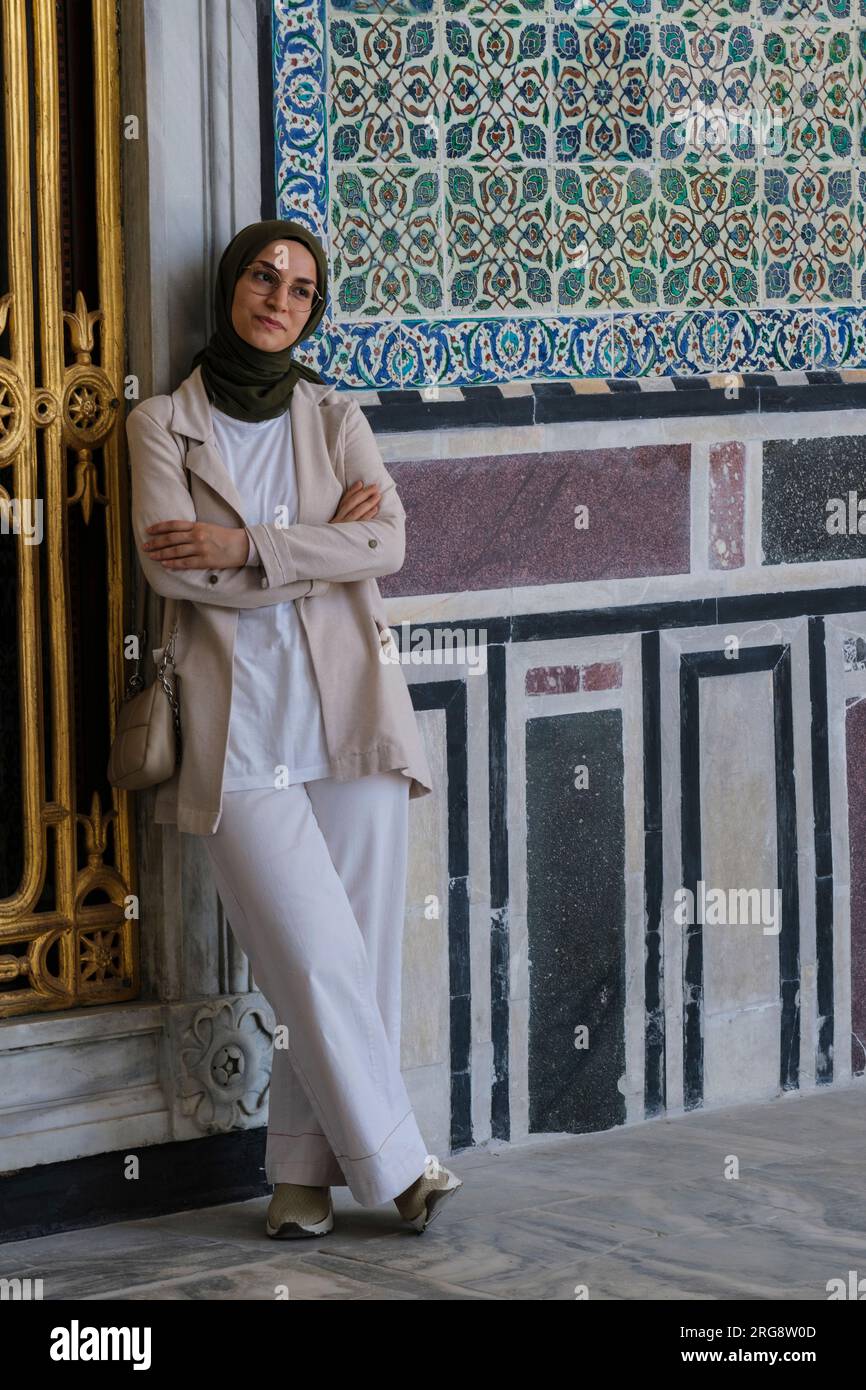 Istanbul, Türkei, Türkiye. Türkische Frau in Hijab und konservative Kleidung, die für Foto im Topkapi-Palast posiert. NICHT FÜR LIZENZIERUNG IN DER TÜRKEI VERFÜGBAR. Stockfoto