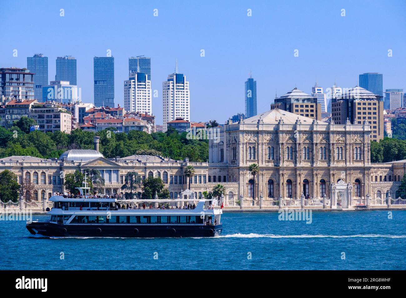 Istanbul, Türkei, Türkiye. Touristenboot, das am Dolmabahce-Palast vorbeifährt, vom Bosporus aus gesehen. Stockfoto