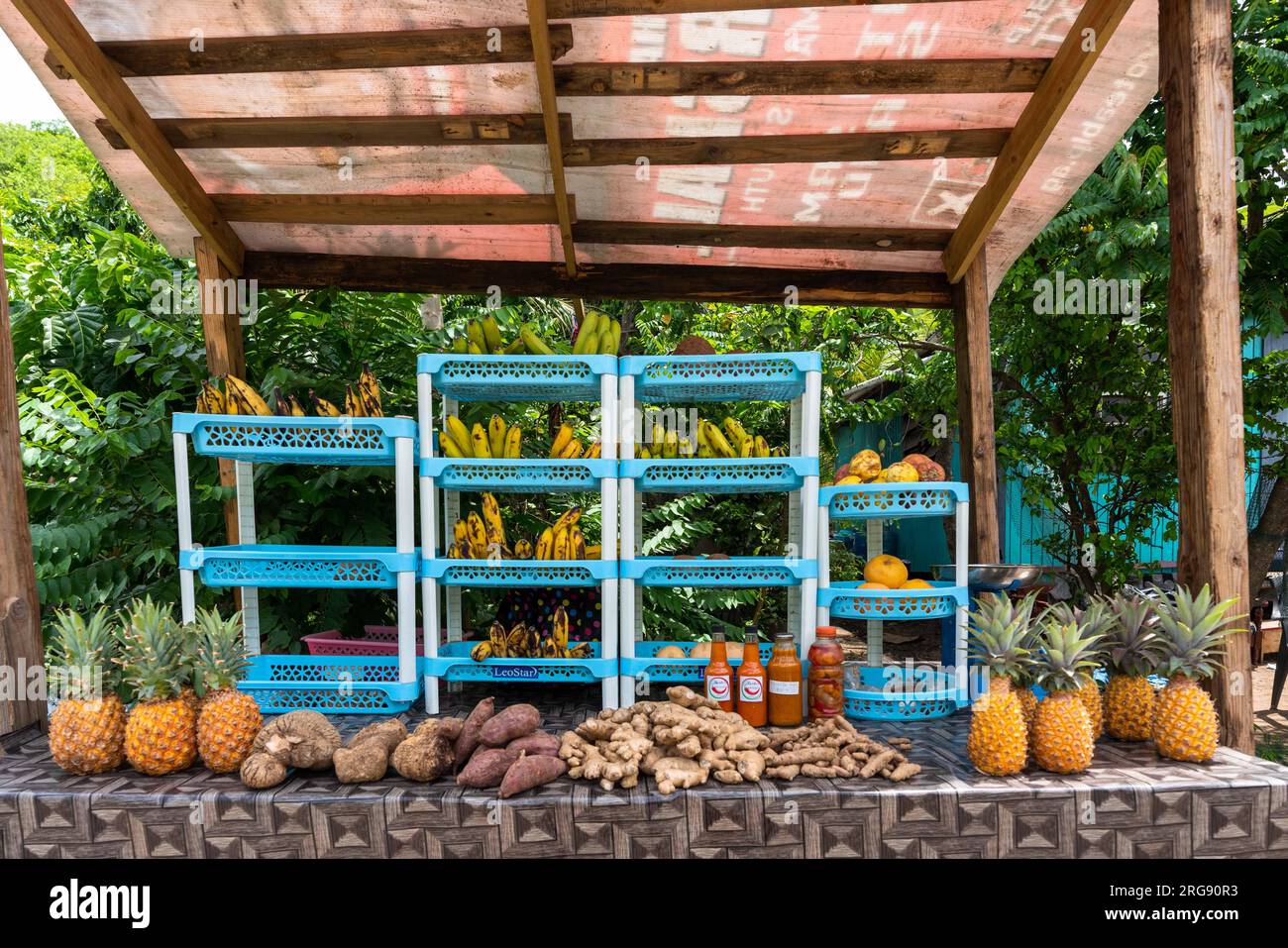 Ein Supermarkt am Straßenrand, Antigua, der Ananas, Bananen, Mangos und scharfe Soße verkauft Stockfoto