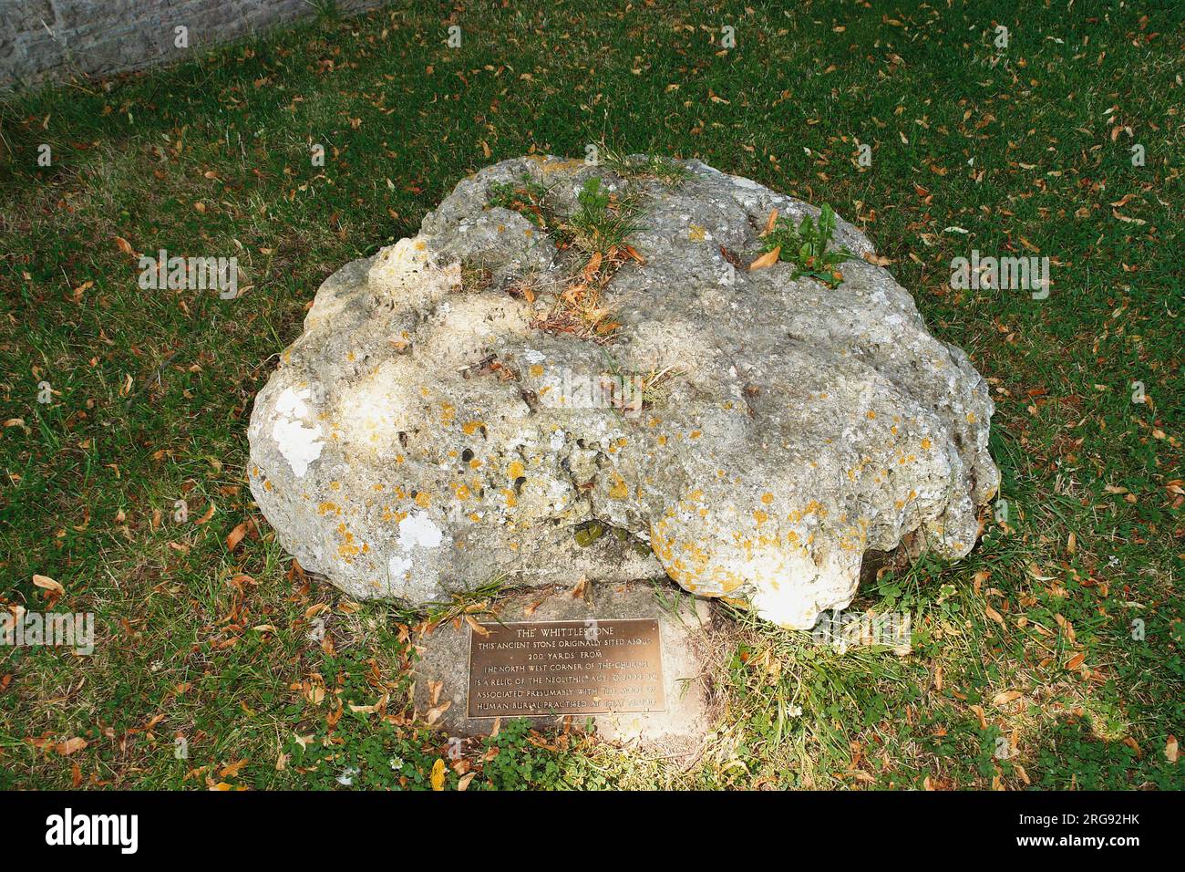 The Whittlestone, ein stehender Stein oder Menhir in Lower Swell, nahe Chipping Norton, Gloucestershire. Es ist auch bekannt als Whistlestone, Wissel Stone und Wittelstone. Die Tafel erklärt, dass der Stein ein Relikt der Jungsteinzeit ist, etwa 2000 v. Chr., und eine Verbindung zu menschlichen Begräbnissen hat. Stockfoto