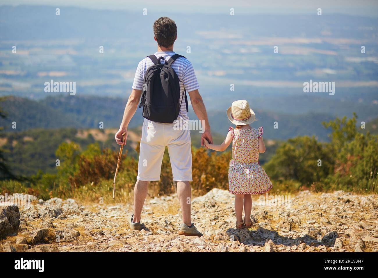 Vater und Tochter genießen einen wunderschönen Blick von der Spitze des Hügels in der Provence, Südfrankreich. Glückliche Familie mit zwei Personen, die zusammen reisen Stockfoto