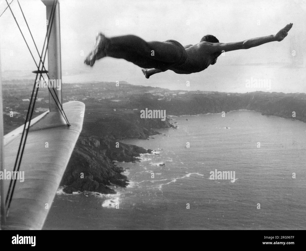 Ein Mann, der aus einem Flugzeug ins Meer zu springen scheint. Stockfoto