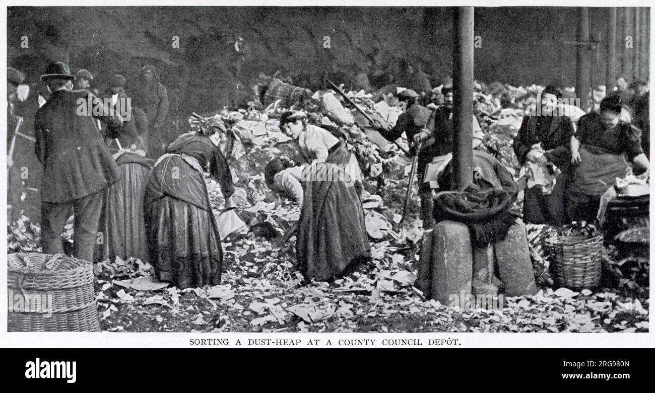 Männer verteilen Müllhaufen, während Frauen nach einem ehrlichen Penny suchen, der Flaschen und leere und sardinische Dosen im Bezirksdepot in London sammelt. Stockfoto