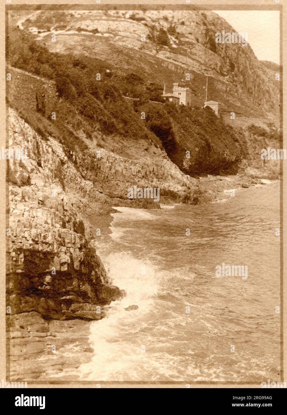 Meerblick, Llandudno, Nordwales, mit Tollgate House (West Shore Lodge Gate) auf dem Marine Drive, das oben sichtbar ist. Stockfoto