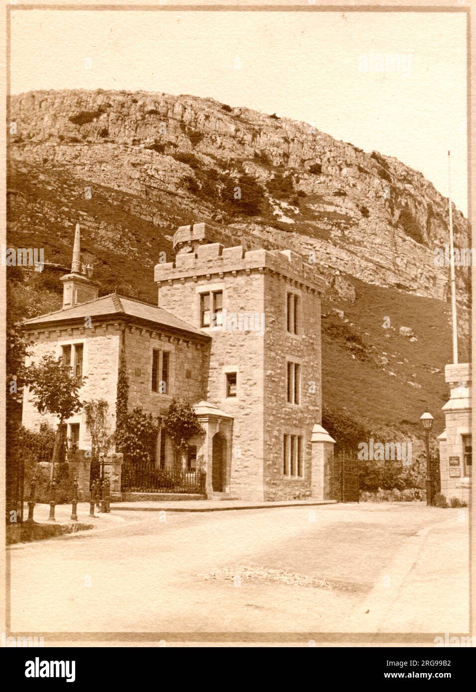 Tollgate House (West Shore Lodge Gate), Marine Drive, Llandudno, North Wales, mit Klippen darüber. Stockfoto