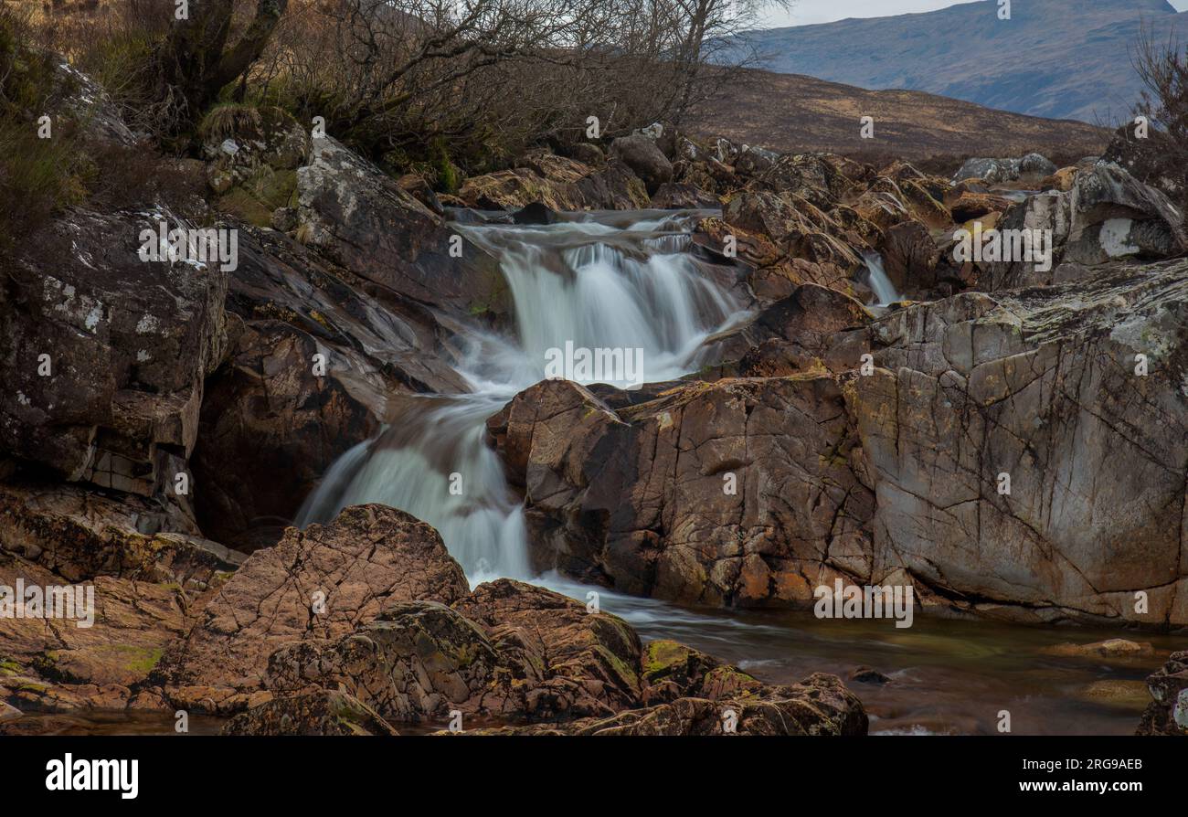 Langsame, seidenweiche Wasseraufnahme des Wasserfalls und des Berges Buichaille Etive More in Glencoe, Schottland Stockfoto