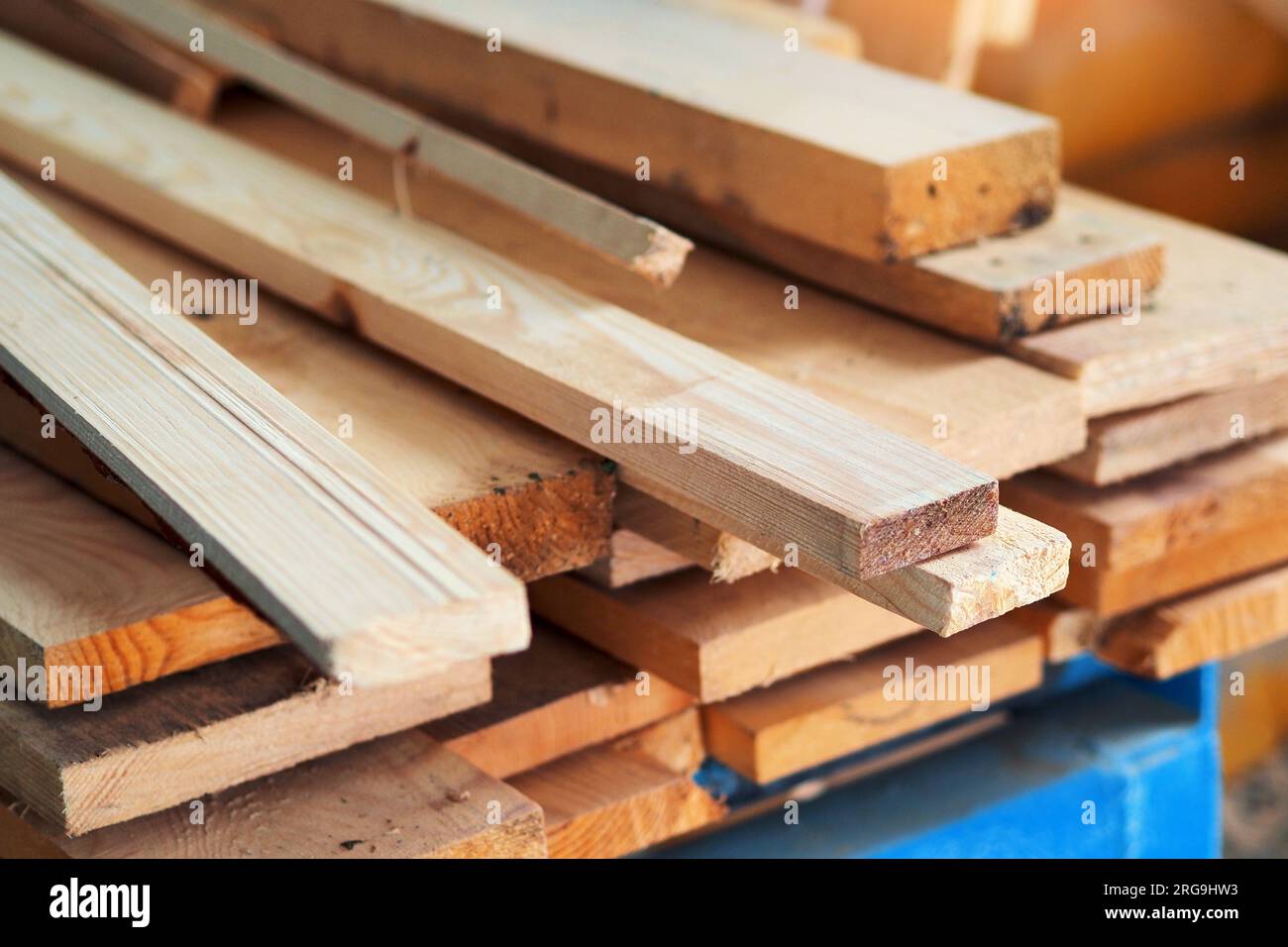 Neue gehobelte Holzbretter im Sägewerk gestapelt. Beschaffung und Verkauf von Baumaterial. Trockenes Holz. Holzbearbeitung. Hintergrund. Stockfoto