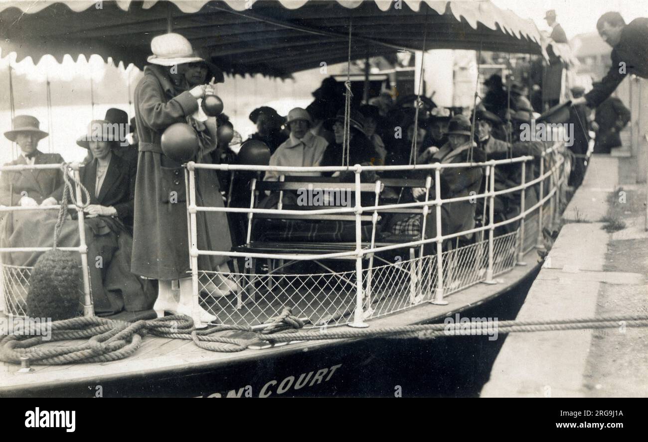 Das Flussboot „Hampton Court“ bereitet sich auf eine Bootsfahrt mit Tagesausflüglern auf die Themse in Windsor vor. Die Frau im Vordergrund jagt ein paar Ballons in die Luft - vielleicht hat jemand Geburtstag?! Das Hampton Court führt Besucher bis heute immer noch die Themse hoch und runter! Stockfoto