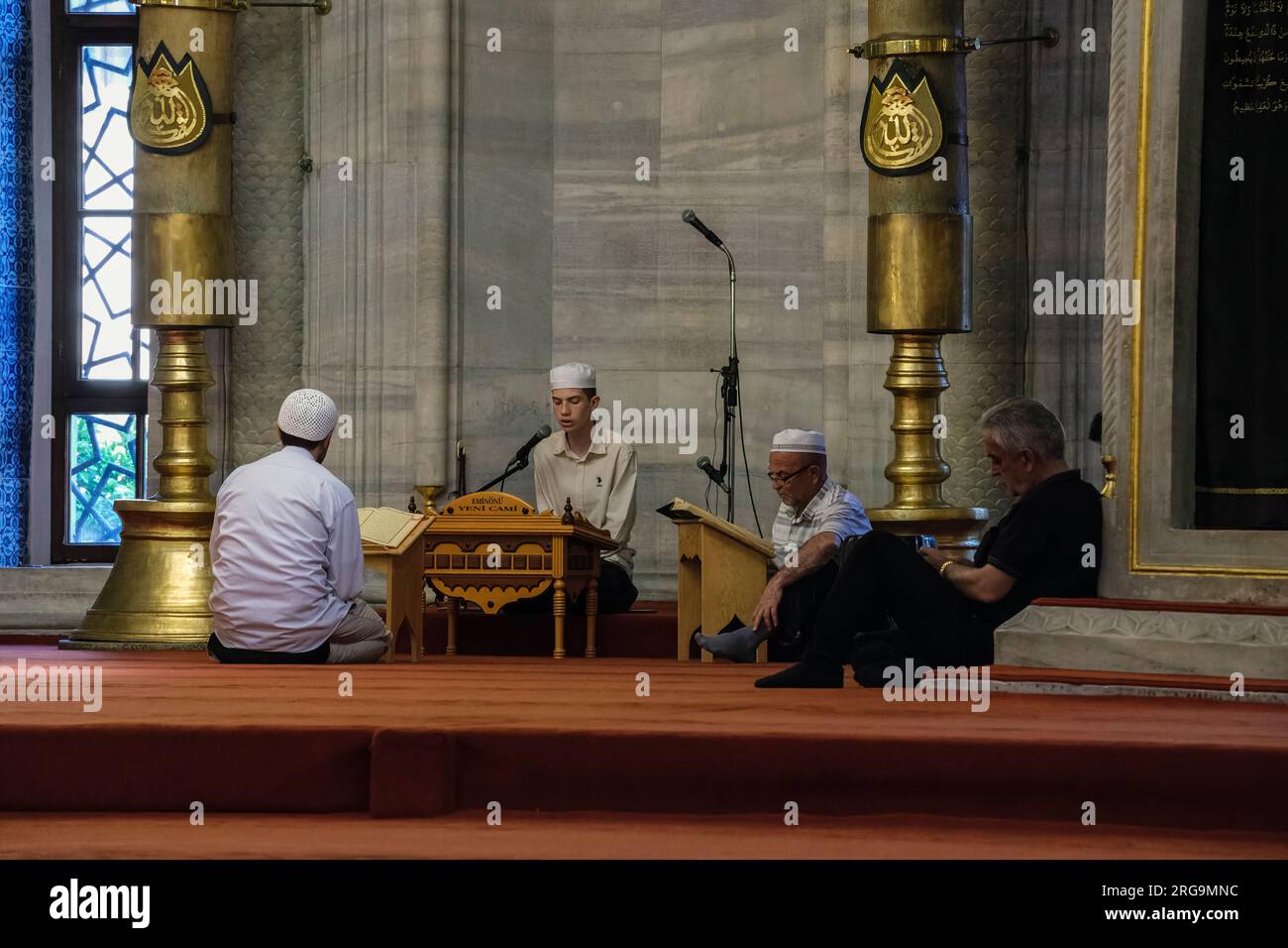 Istanbul, Türkei, Türkiye. Neue Moschee (Yeni Camii). Imam rezitiert vor den Gebeten aus dem Koran. Stockfoto