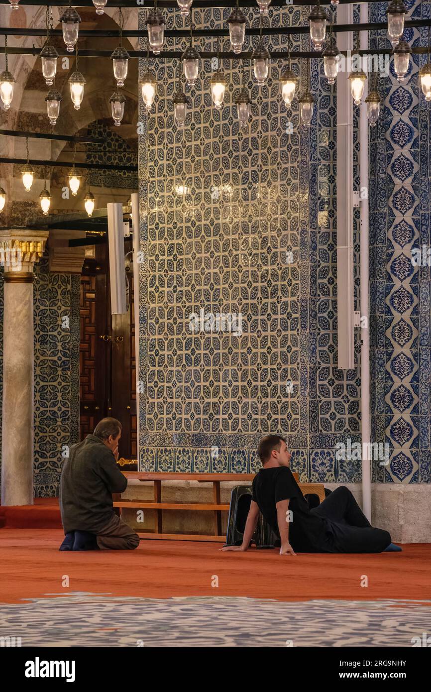 Istanbul, Türkei, Türkiye. Männer warten auf das Gebet in der Neuen Moschee (Yeni Camii) Stockfoto