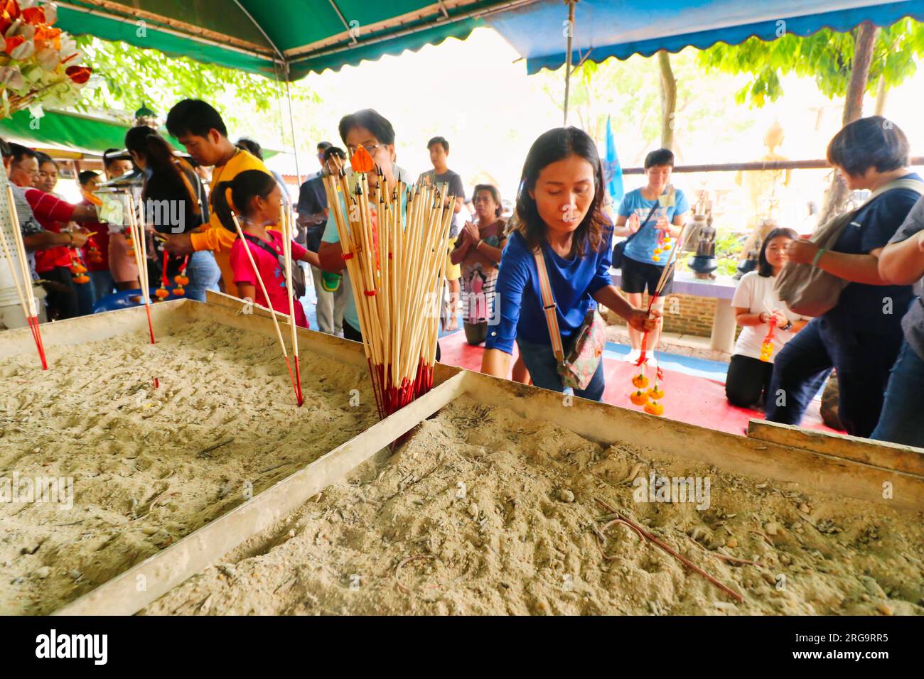 24. Dezember 2018, Bangkok, Thailand - Tempelbesucher zünden Räucherstäbchen an einem buddhistischen Schrein in der Nähe von Maeklong, Thailand an Stockfoto