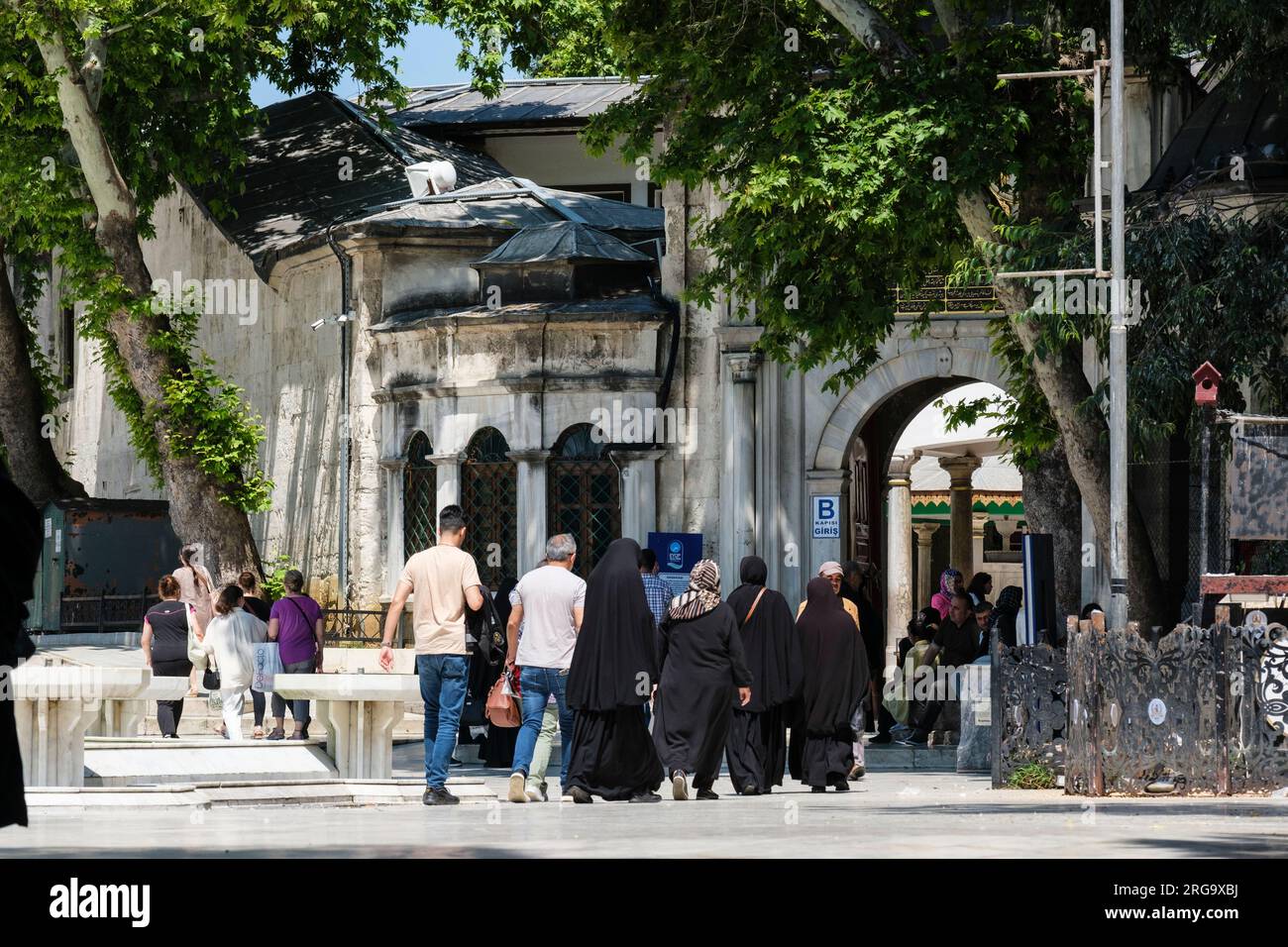 Istanbul, Türkei, Türkiye. Leute betreten den Eyup Sultan Moschee Innenhof. Stockfoto