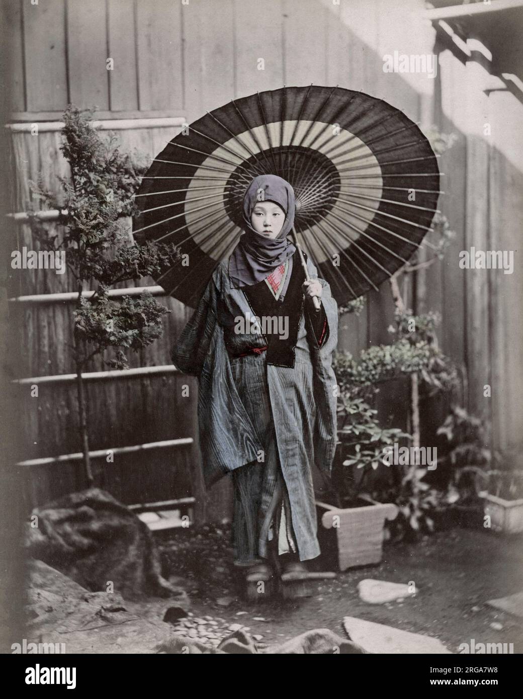 Junge Japanerin im Winterkostüm mit Regenschirm. Vintage 19. Jahrhundert Foto. Stockfoto