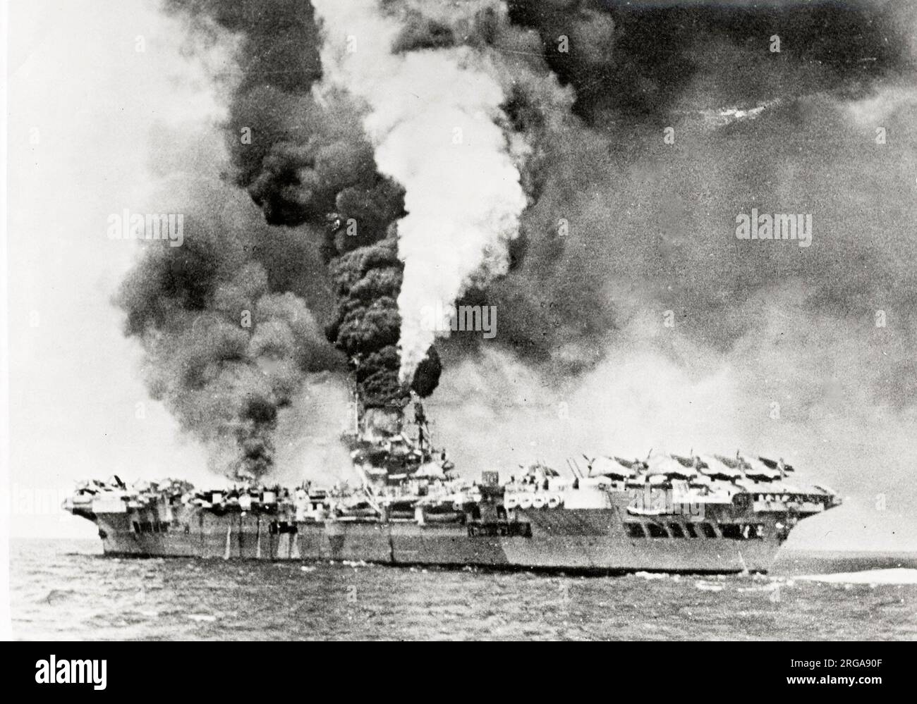 Vintage-Foto des Zweiten Weltkriegs - Rauch strömt von britischem Flugzeugträger nach einem Angriff durch Jaapanese Selbstmordattentäter Kamikaze Stockfoto