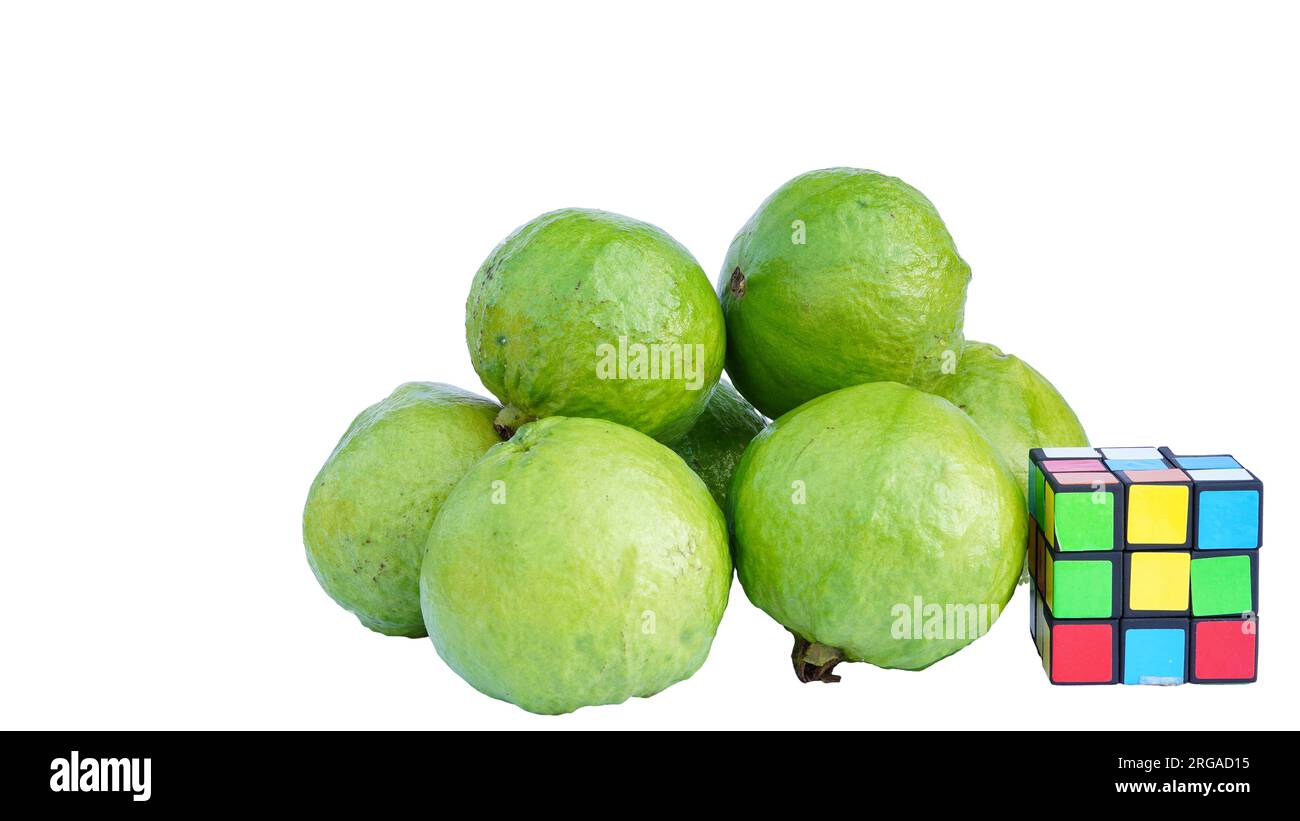 Rubikwürfel und grüne Guave isoliert auf weißem Hintergrund. Stockfoto